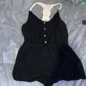 a black romper with four buttons down the middle.